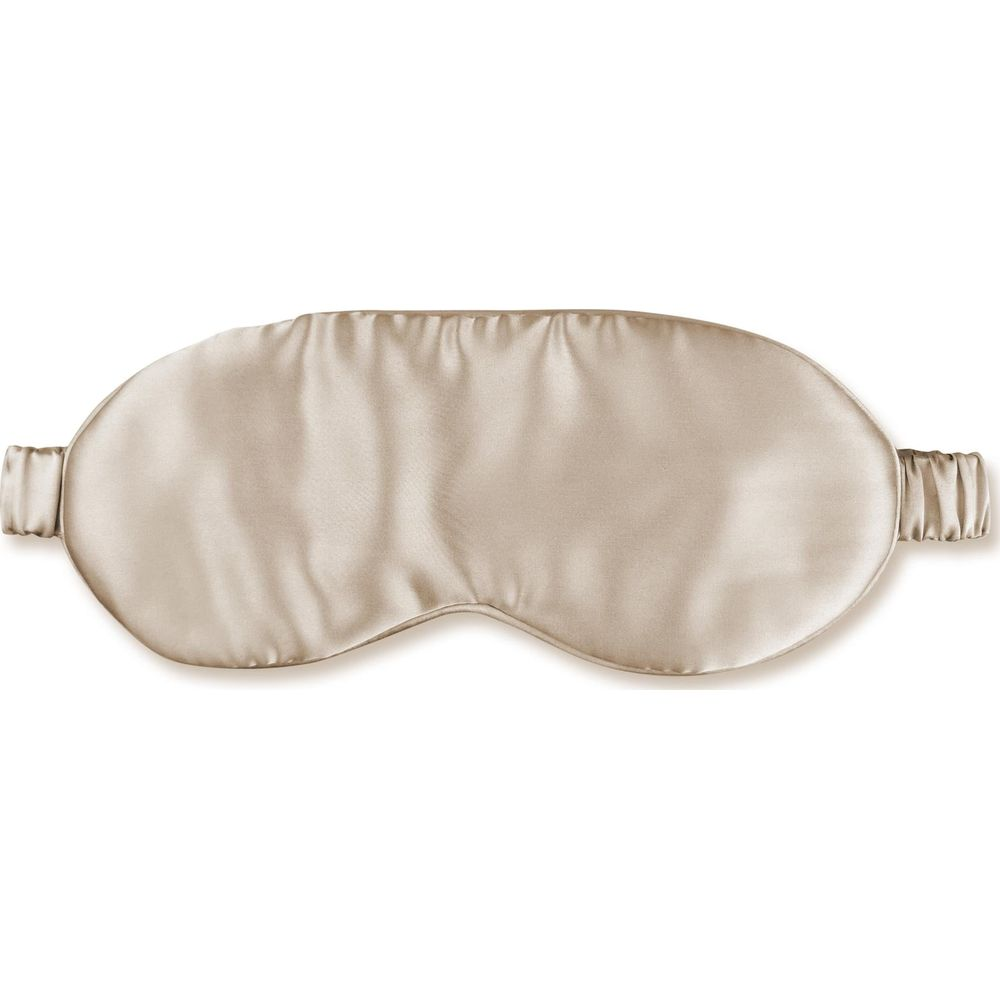Eine glänzende, beige Seidenschlafmaske auf weißem Hintergrund.