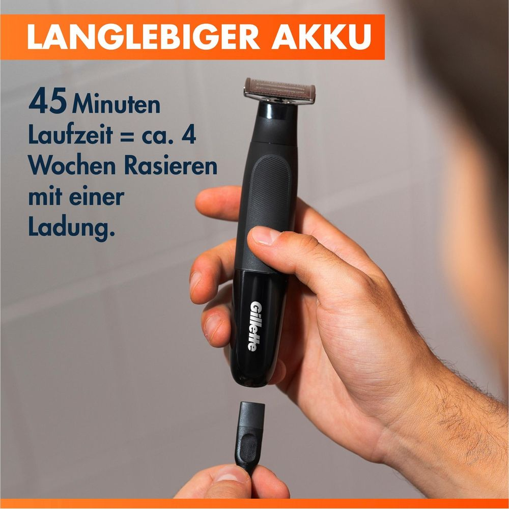 Mano che tiene un rasoio Gillette nero con cavo di ricarica. Il testo sull'immagine promuove una batteria a lunga durata.