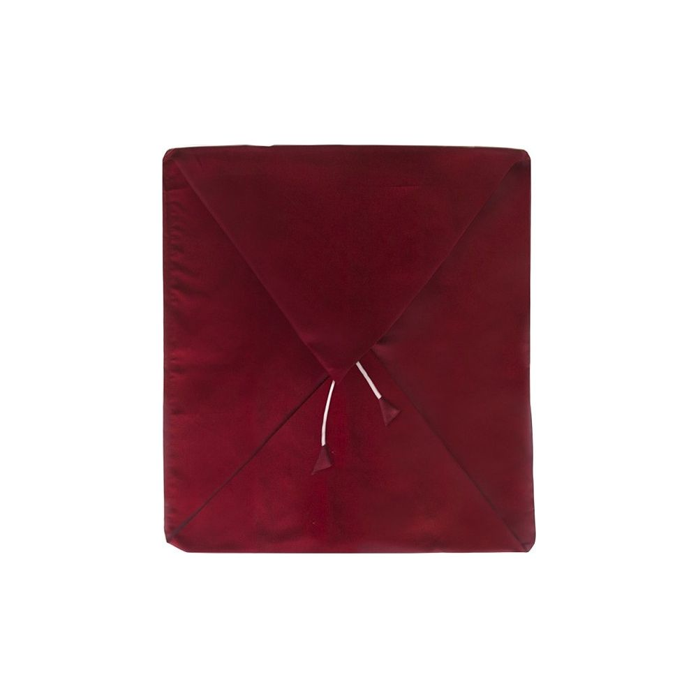 Un involucro di tessuto rosso scuro piegato, legato con sottili cordini bianchi su sfondo bianco.