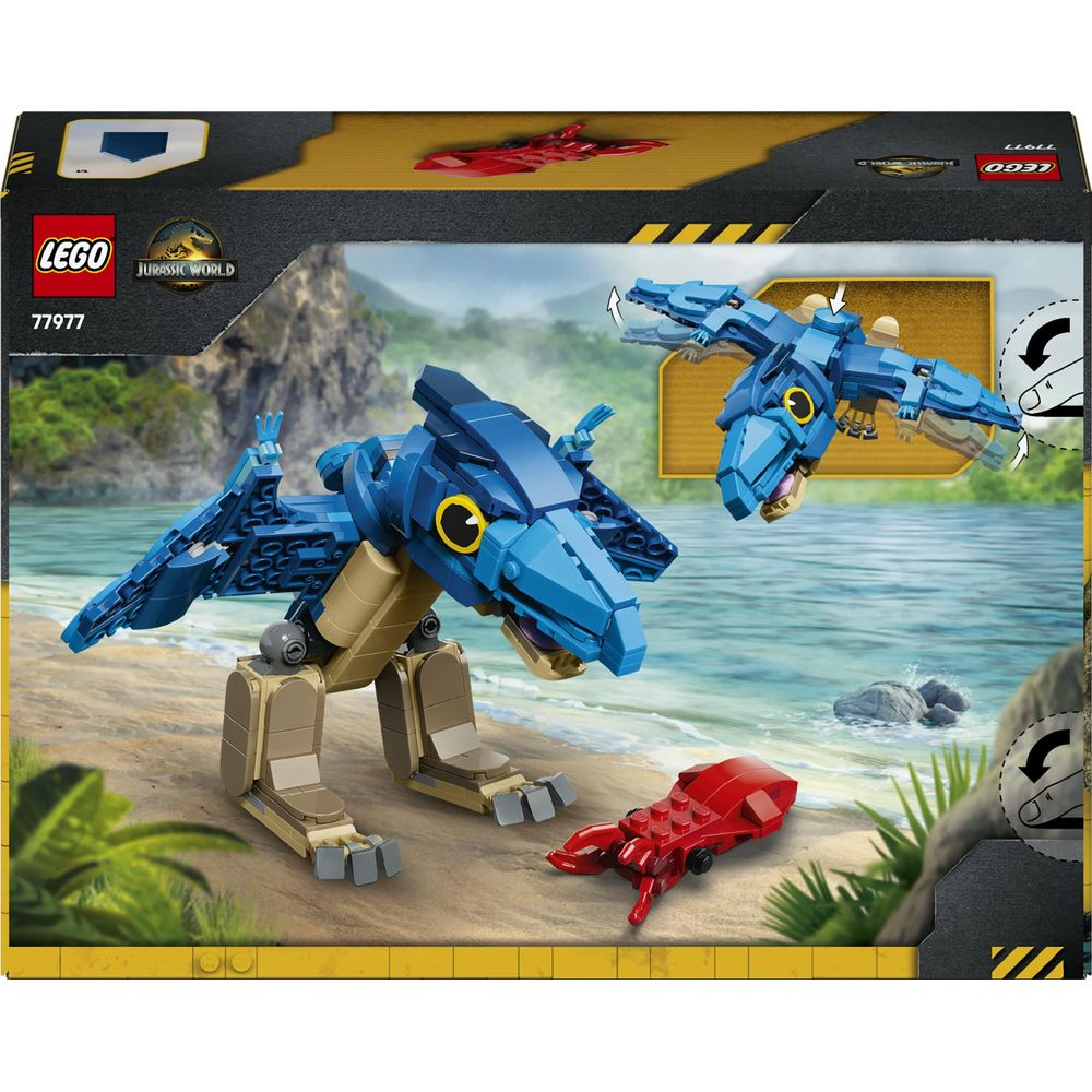 Scatola Lego Jurassic World con Pteranodon blu e insetto rosso su una spiaggia.