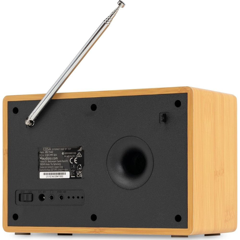 La parte trasera de una radio de madera con antena extendida, puertos, etiqueta y puerto de graves en panel negro.