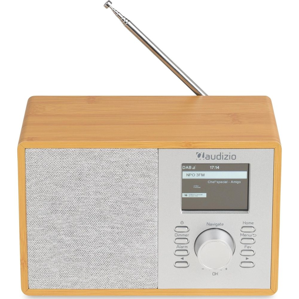 Una radio de madera con panel plateado, pantalla, botones, mando central y antena extendida sobre fondo blanco.
