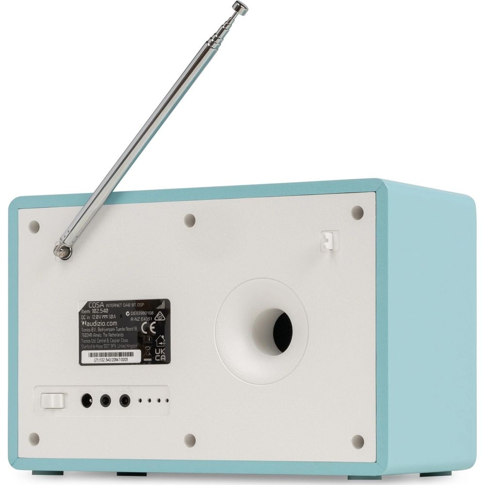 Parte trasera de una radio azul claro con panel blanco, antena extendida, puerto de altavoz y conectores.