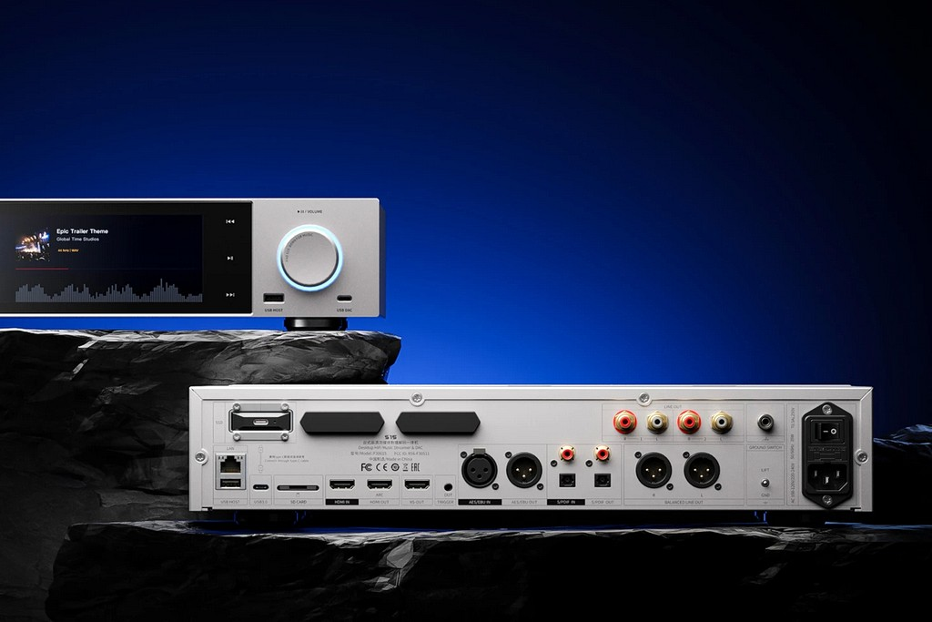 Vista frontal y trasera de un streamer de audio HiFi plateado sobre roca negra con fondo azul.