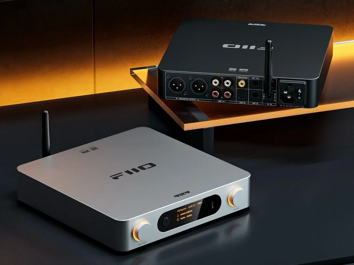 Dos dispositivos de audio FiiO con antenas en una mesa oscura; el delantero es plateado y el trasero negro.