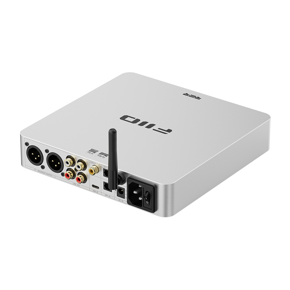 Un amplificador de audio FiiO plateado con varios puertos de conexión y una antena en la parte trasera.