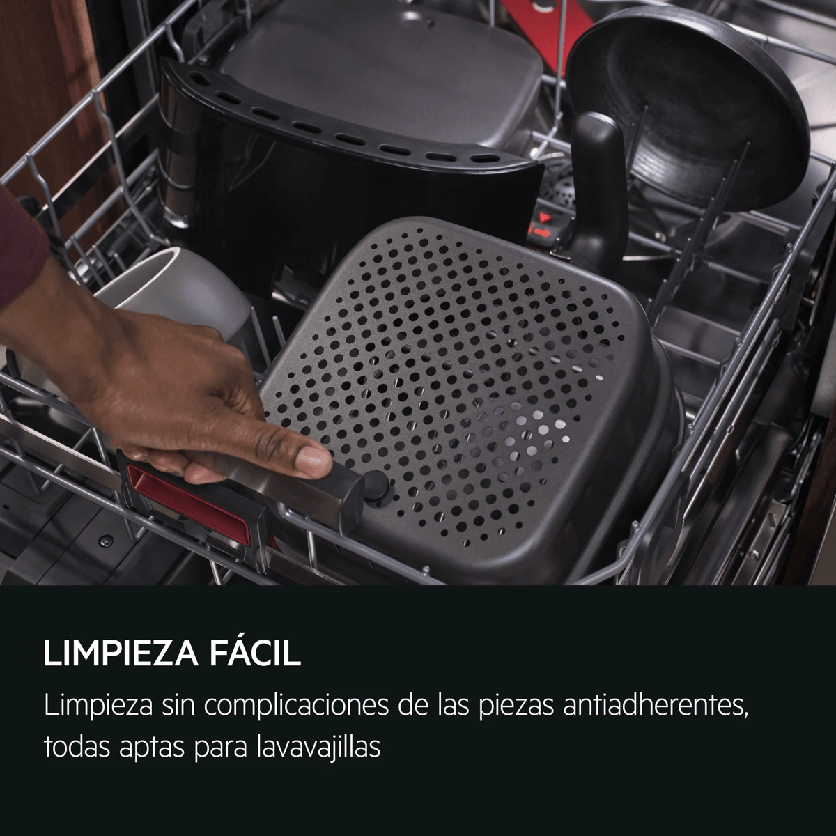 Una mano coloca una cesta de freidora de aire en un lavavajillas lleno.
