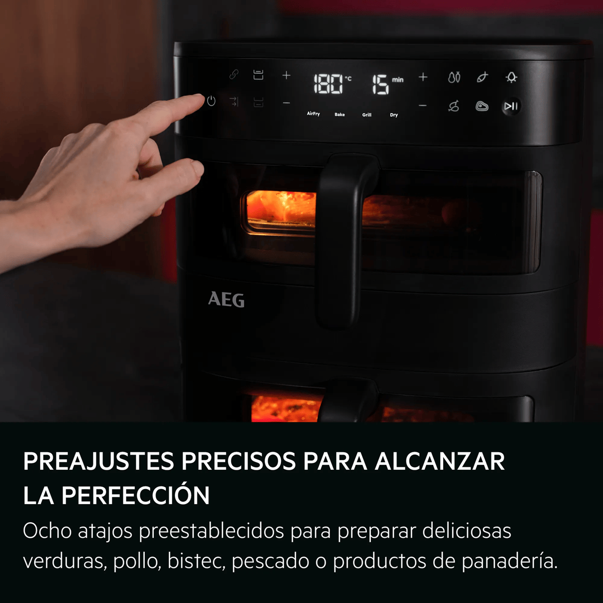 Una mano presiona el botón de encendido de una freidora de aire AEG negra con pantalla digital.