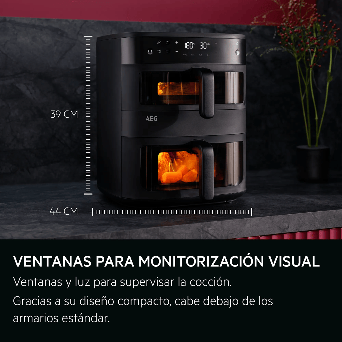 Freidora de aire AEG negra con dos cajones y ventanas iluminadas en una encimera de cocina.