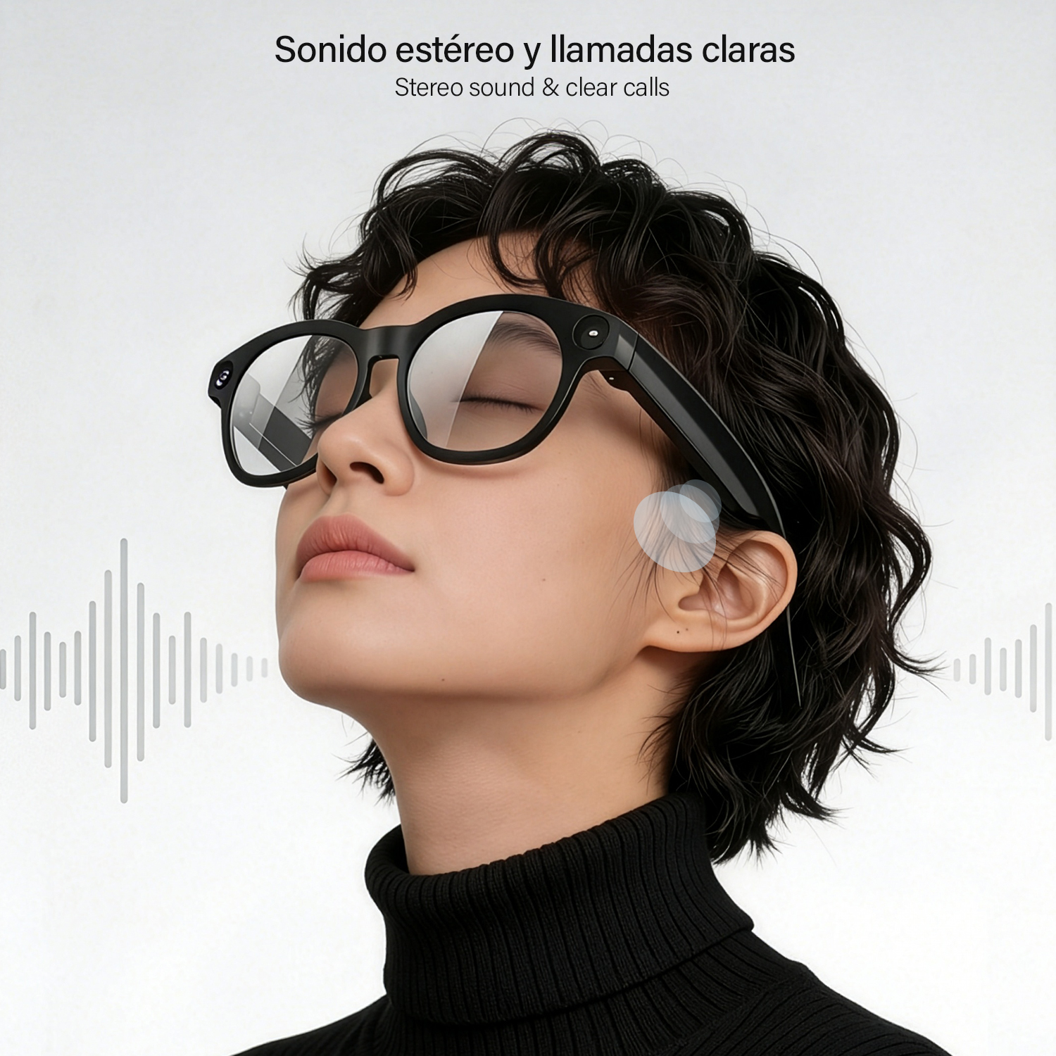 Una mujer con cabello oscuro corto lleva gafas inteligentes negras y un suéter negro de cuello alto sobre fondo blanco.