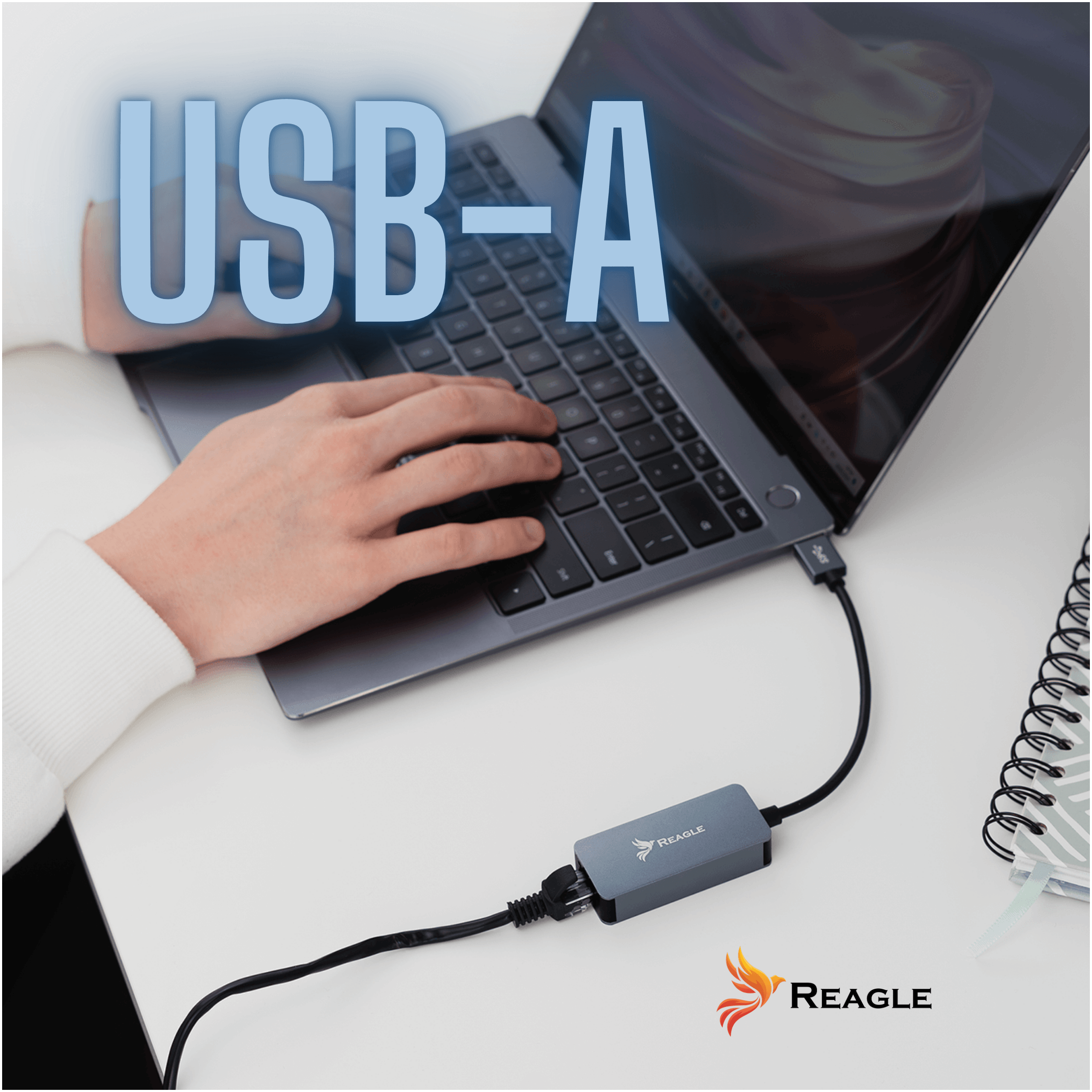 Osoba korzysta z laptopa z podłączonym szarym hubem USB-A na biurku.
