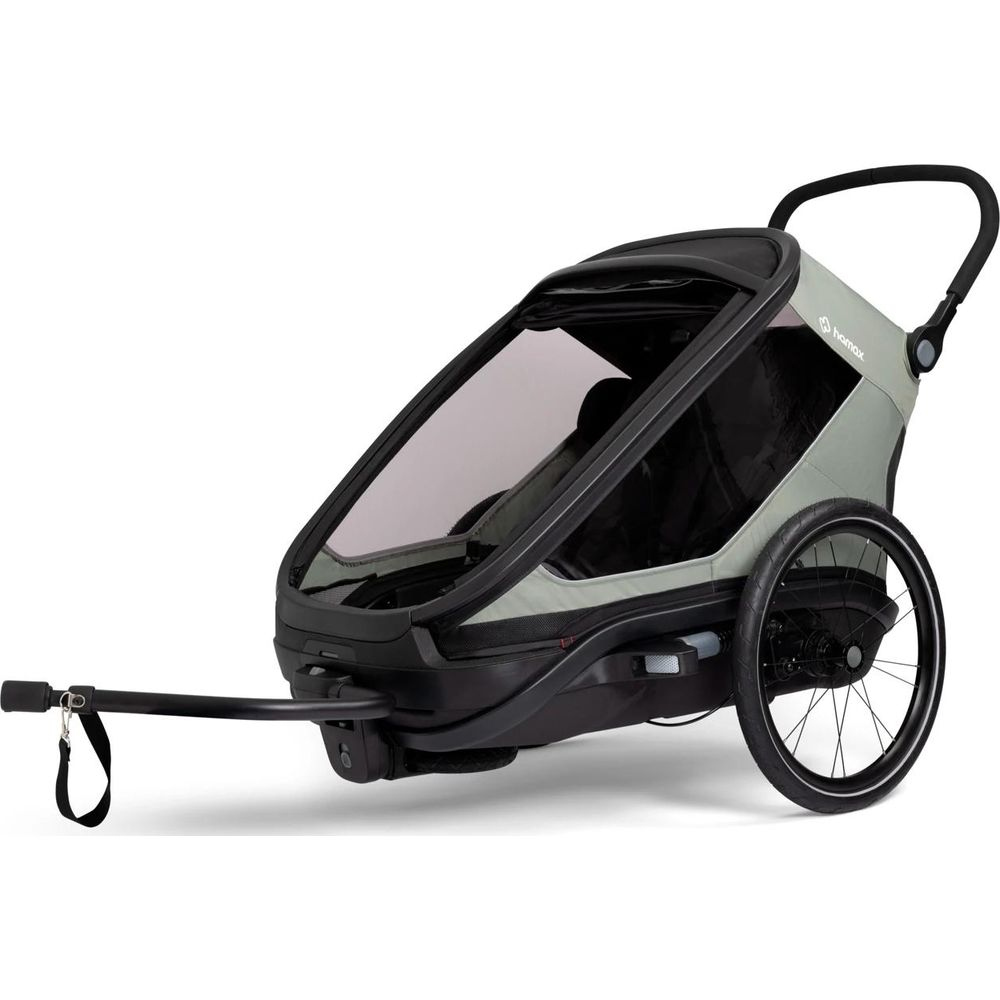 Un remolque de bicicleta para niños gris con ruedas negras y barra de remolque sobre fondo blanco.