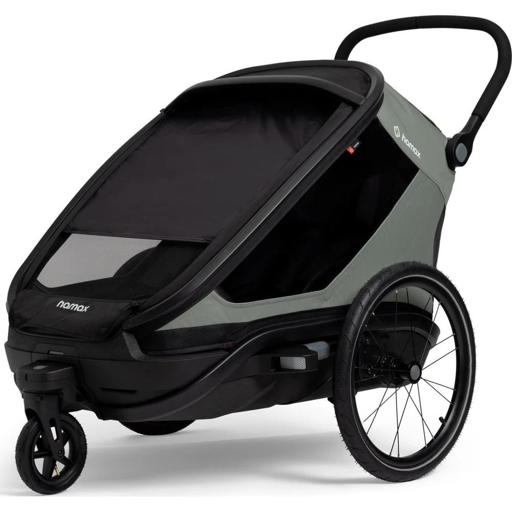 Un remolque de bicicleta para niños gris con capota negra, rueda trasera grande y rueda delantera pequeña.