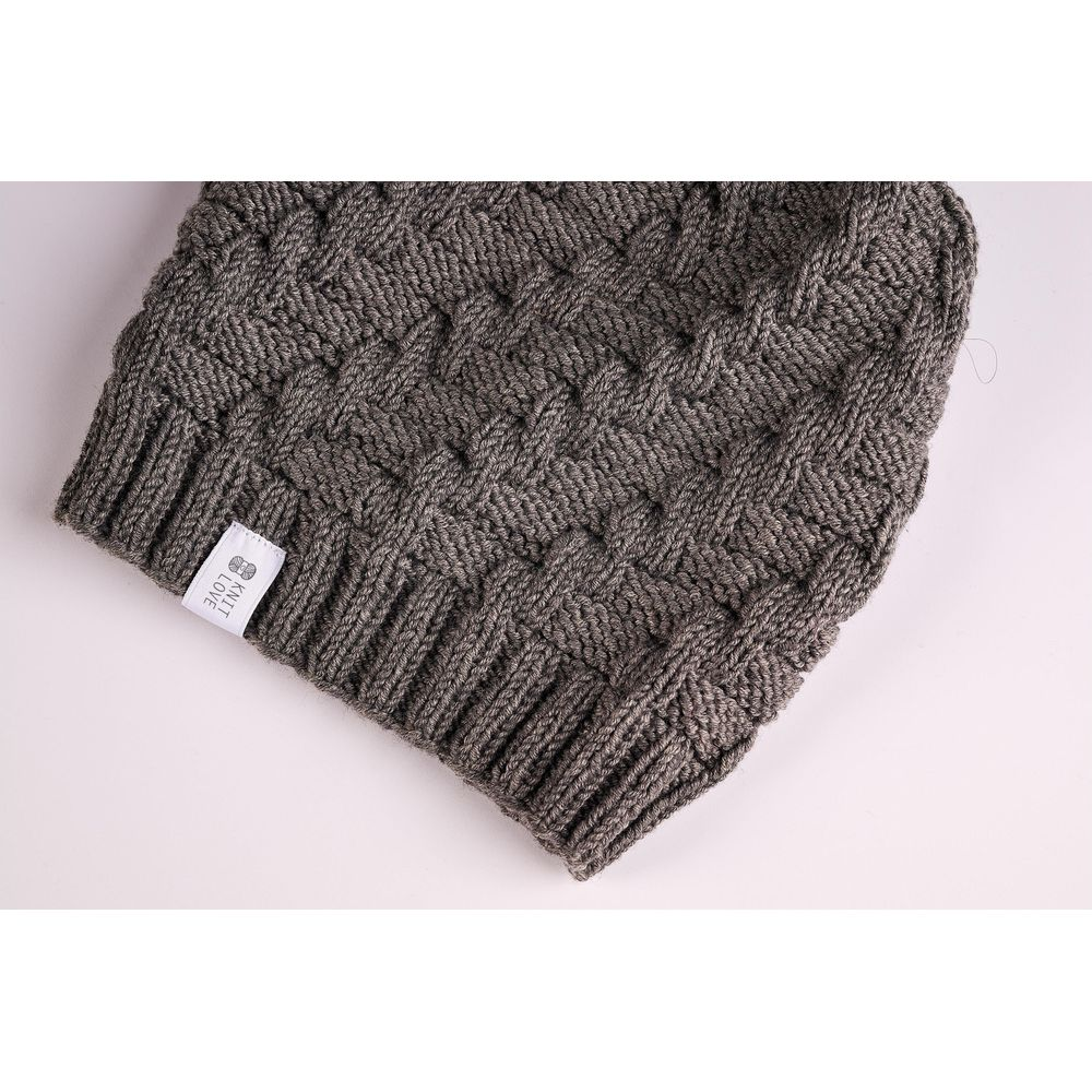 Nahaufnahme einer braunen Strick-Wintermütze mit Strukturmuster und weißem Markenschild am Rippbündchen.