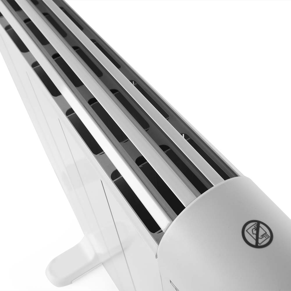 Primer plano de un radiador blanco con ranuras de ventilación y símbolo de prohibido tocar.