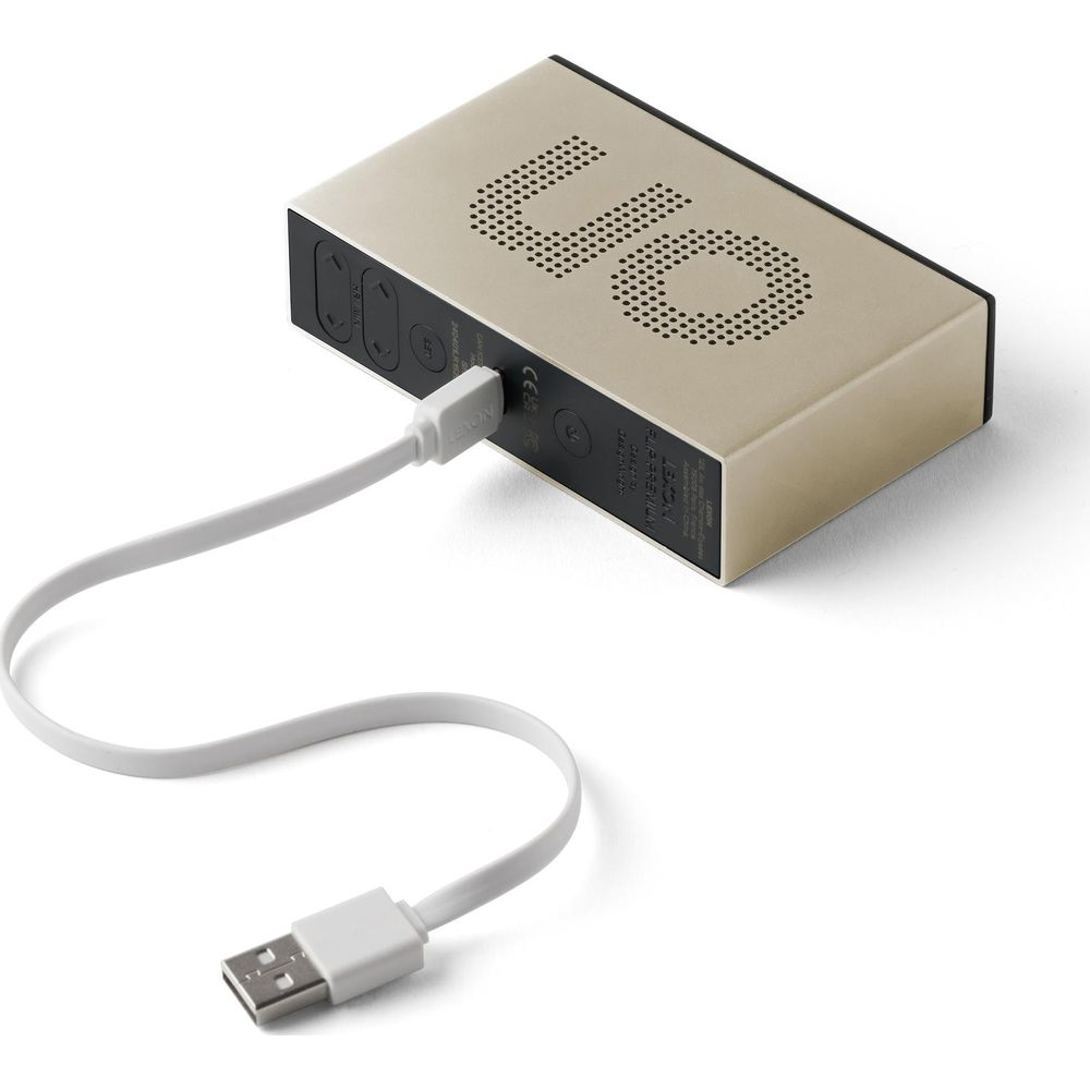 Ein goldenes Digitalgerät mit Ladekabel auf weißem Grund.