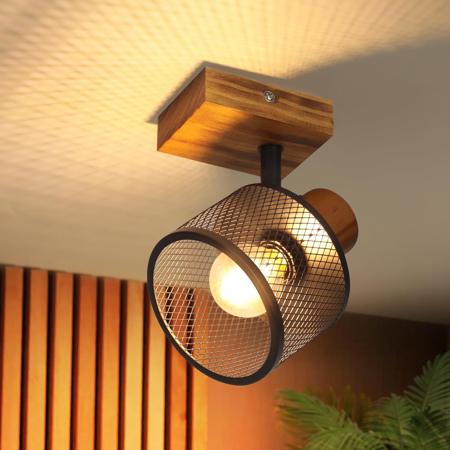 Ein Deckenstrahler aus Holz mit schwarzem Gitter schirm wirft gemustertes Licht.