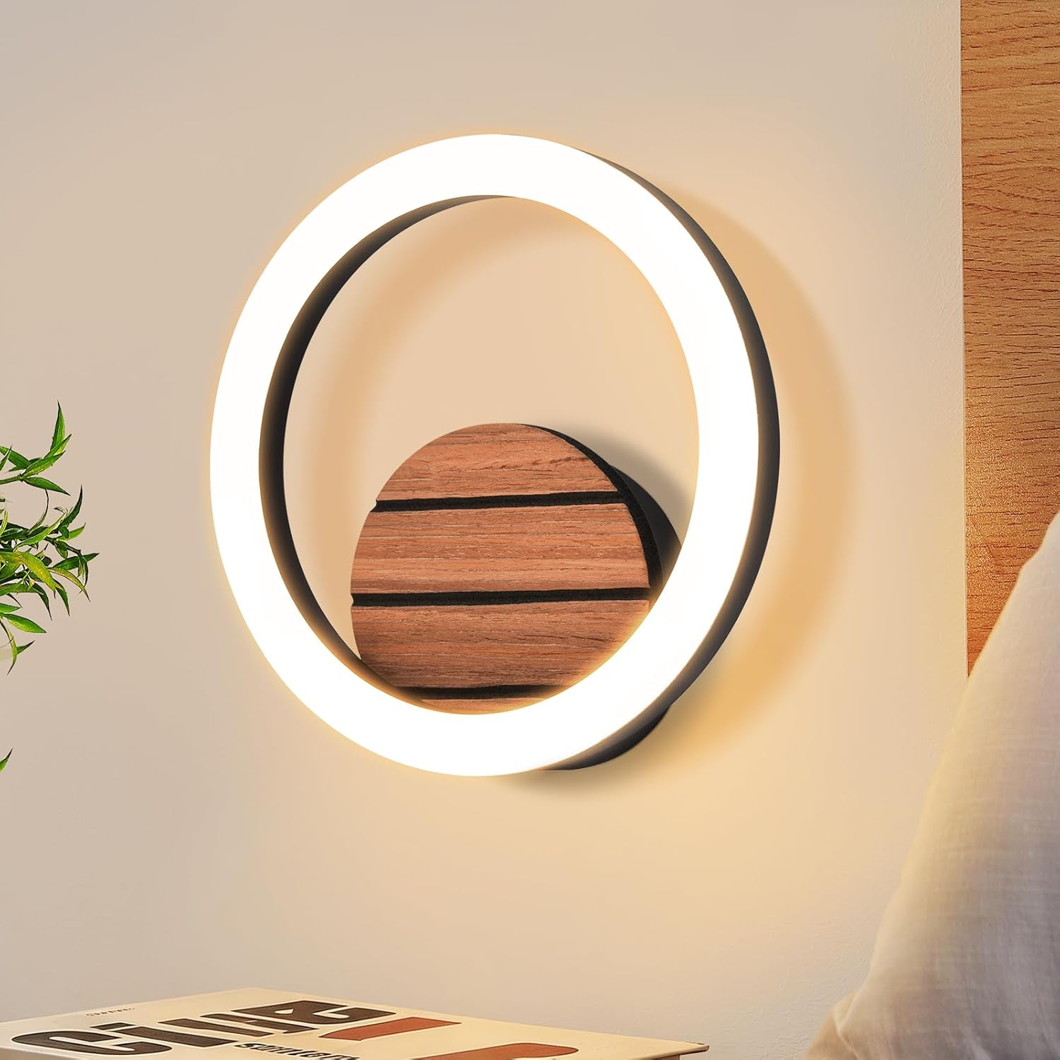 Eine runde LED-Wandleuchte zeigt einen leuchtenden weißen Ring mit dekorativer Holzgrafik an einer hellen Wand.