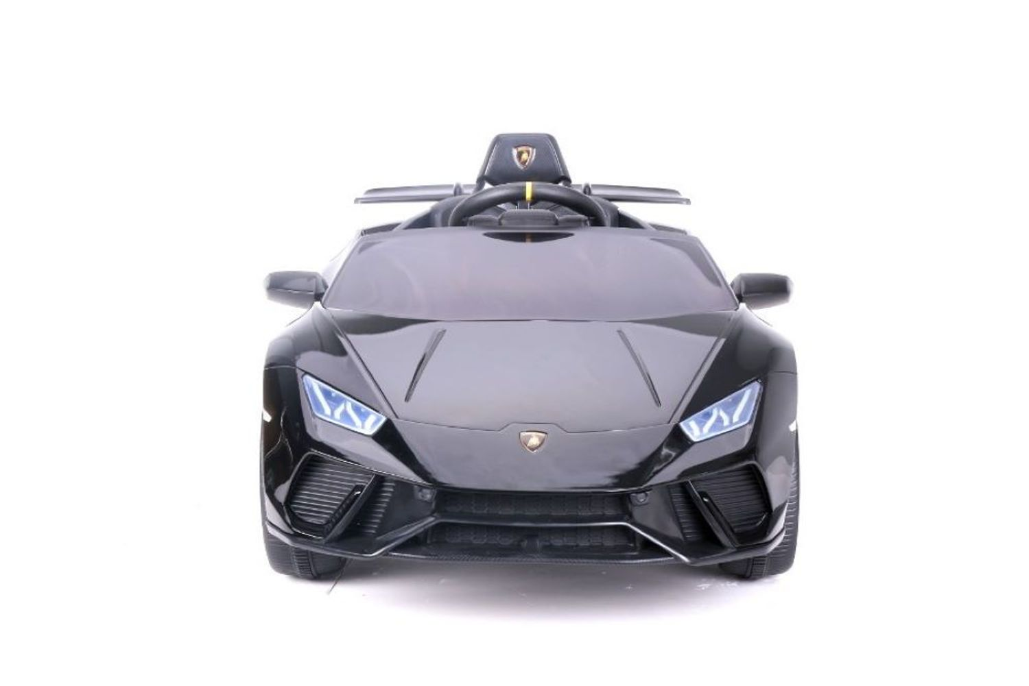Ein schwarzes Spielzeugsportauto mit leuchtend blauen Scheinwerfern vor weißem Hintergrund.