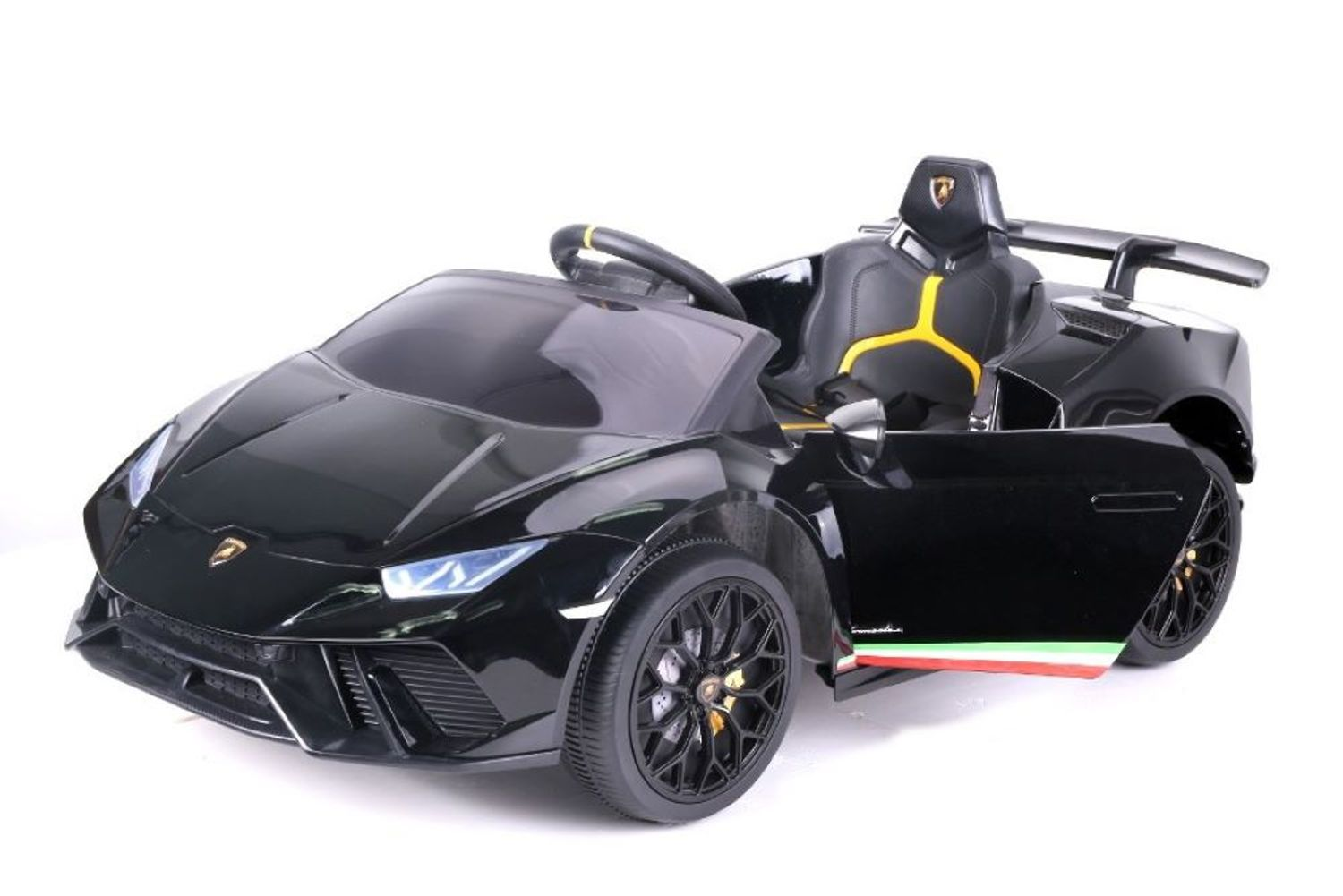 Ein schwarzes Lamborghini-Kinderauto auf weißem Hintergrund mit geöffneter Tür, gelben Akzenten und schwarzen Felgen.