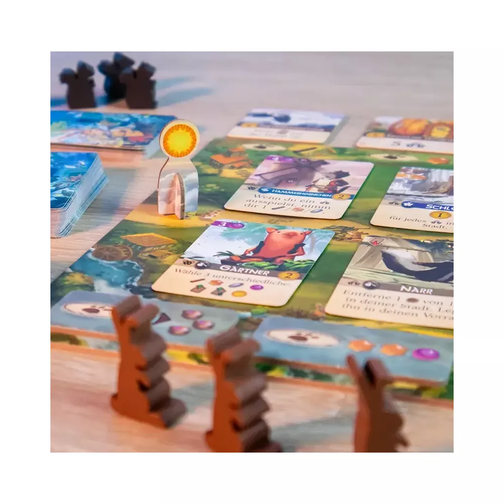 Ein Brettspiel mit bunten Karten, Holzfiguren und einem zentralen Spielplan auf Holztisch.