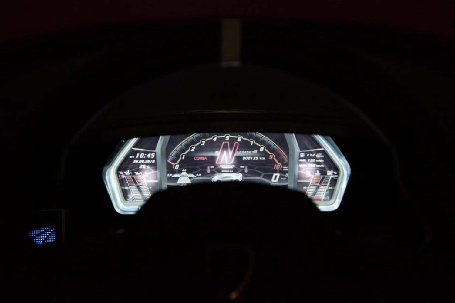 Ein beleuchtetes digitales Armaturenbrett im dunklen Autoinnenraum zeigt eine prominente N-Gang-Anzeige.