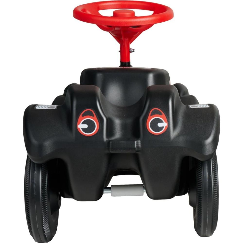 Ein schwarzes Kinder-Rutschauto mit rotem Lenkrad und Augenaufklebern vorne auf weißem Hintergrund.