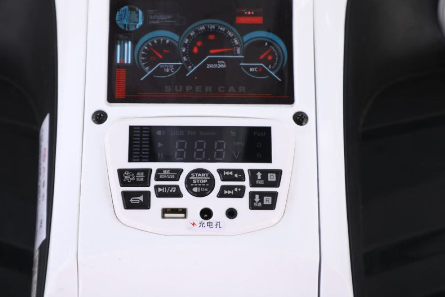 Ein weißes Armaturenbrett eines Spielzeugautos mit einem beleuchteten Display, Tasten, einer USB-Buchse und Lenkradteilen.