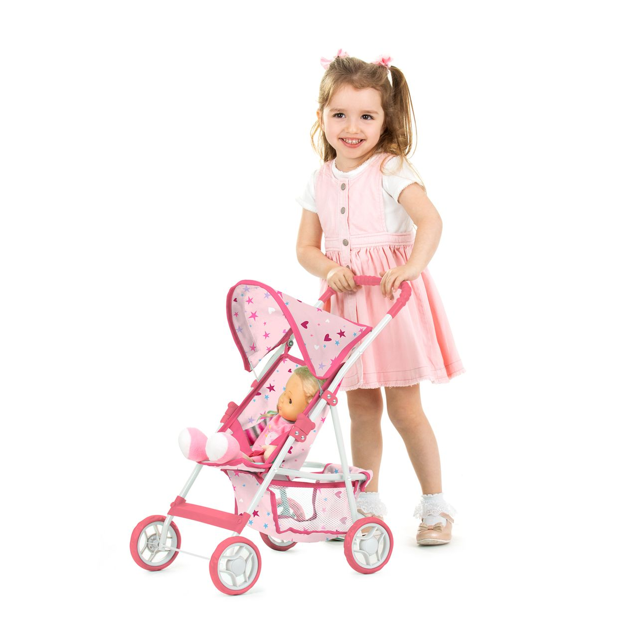 Ein lächelndes Mädchen im rosafarbenen Kleid schiebt einen pinken Puppenwagen mit einer Puppe darin.
