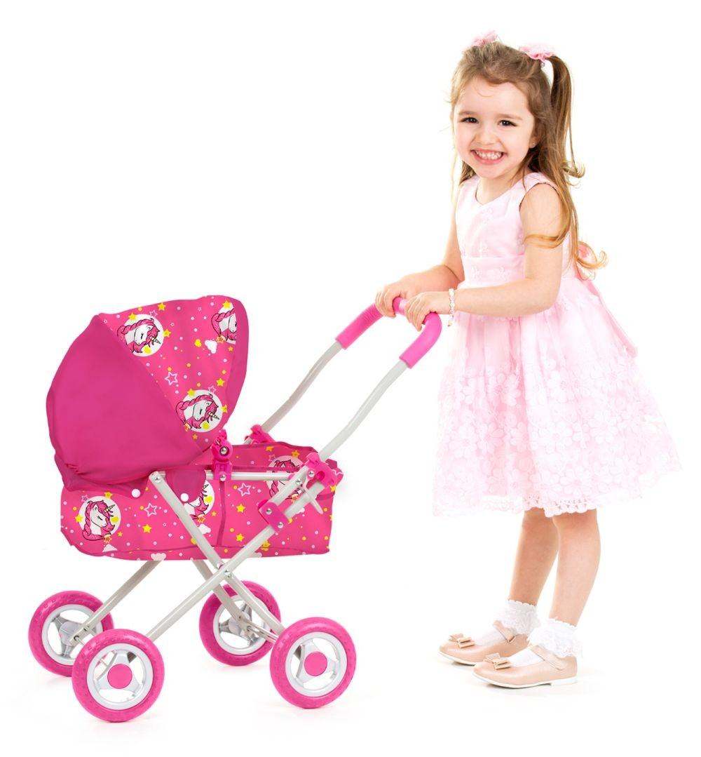 Ein lächelndes Mädchen im rosa Kleid schiebt einen pinken Puppenwagen mit Einhorn-Muster auf weißem Hintergrund.