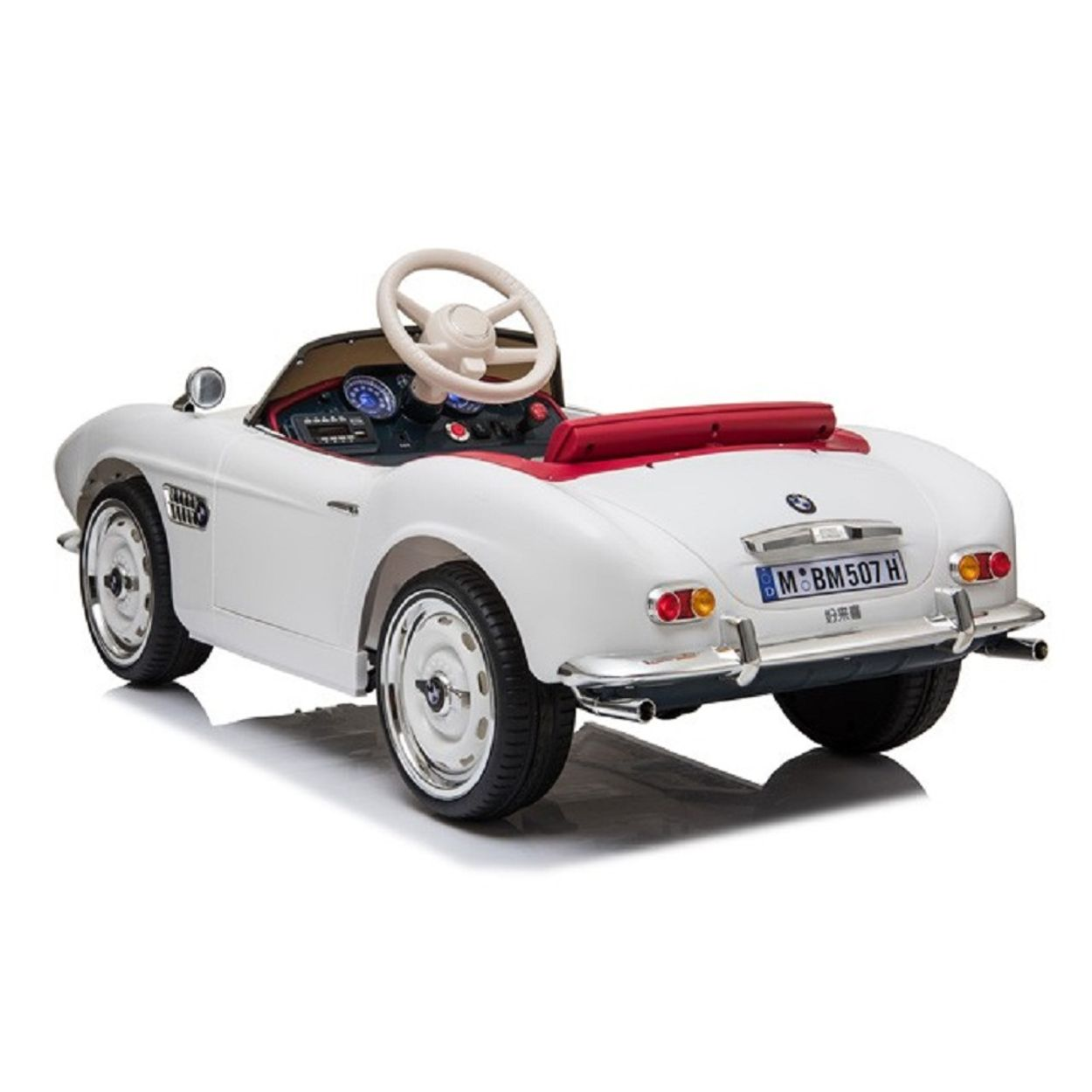 Ein weißes BMW Kinderauto mit rotem Interieur und Chromdetails auf weißem Hintergrund.