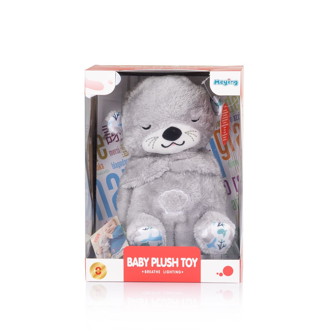 Ein grauer Plüsch-Spielzeugbär in einer Pappschachtel mit der Aufschrift Baby Plush Toy.