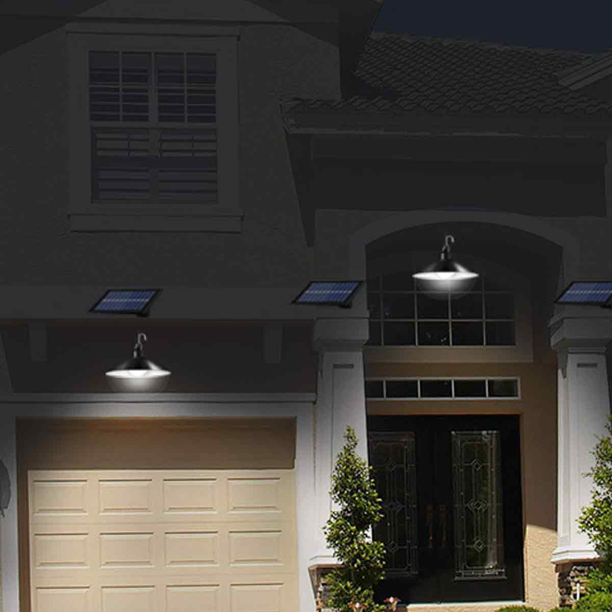 Moderne schwarze Solar-Hängelampen erleuchten den Eingangsbereich und die Garage eines Hauses bei Nacht.