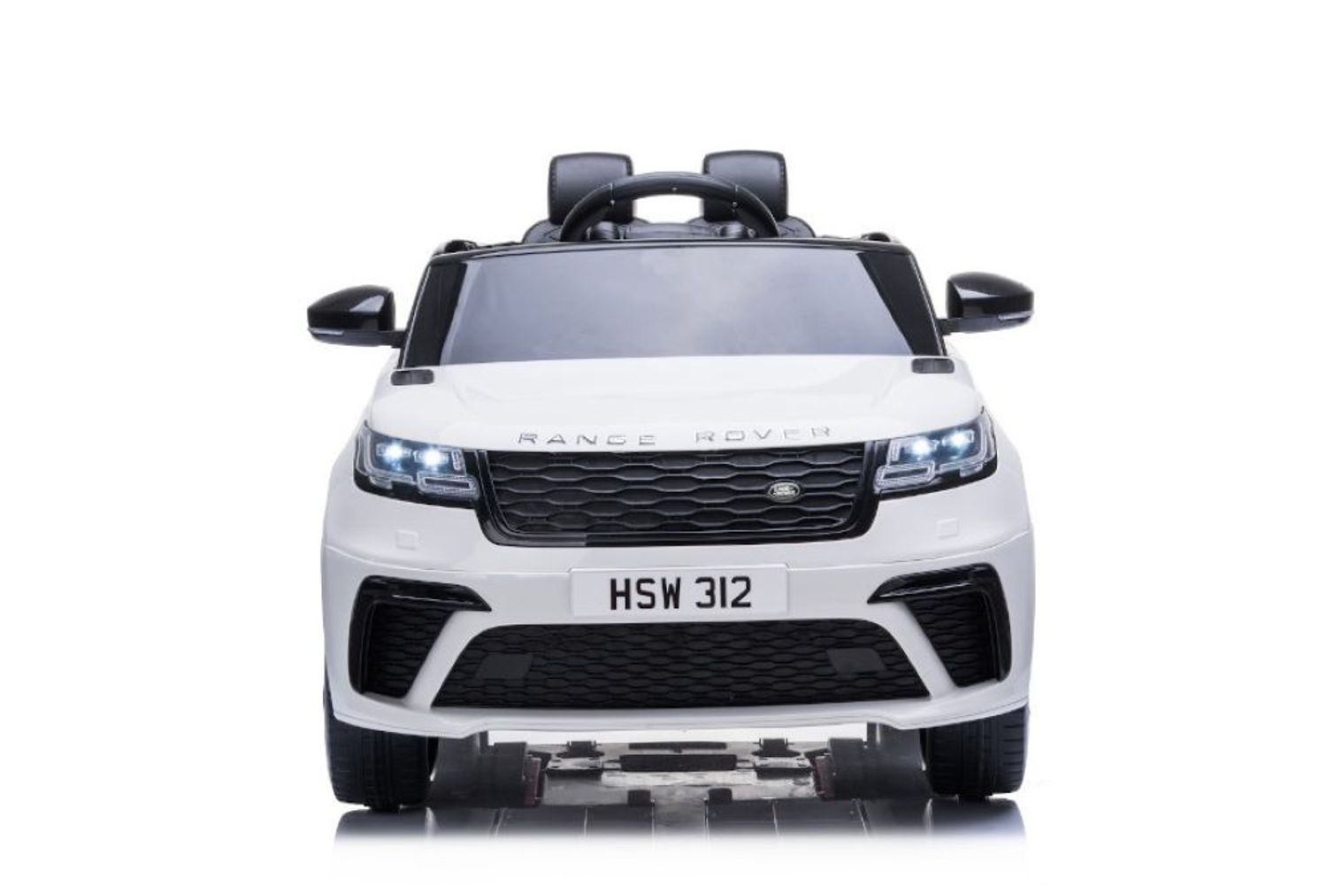 Vorderansicht eines weißen Spielzeug-Range-Rover mit eingeschalteten Scheinwerfern.