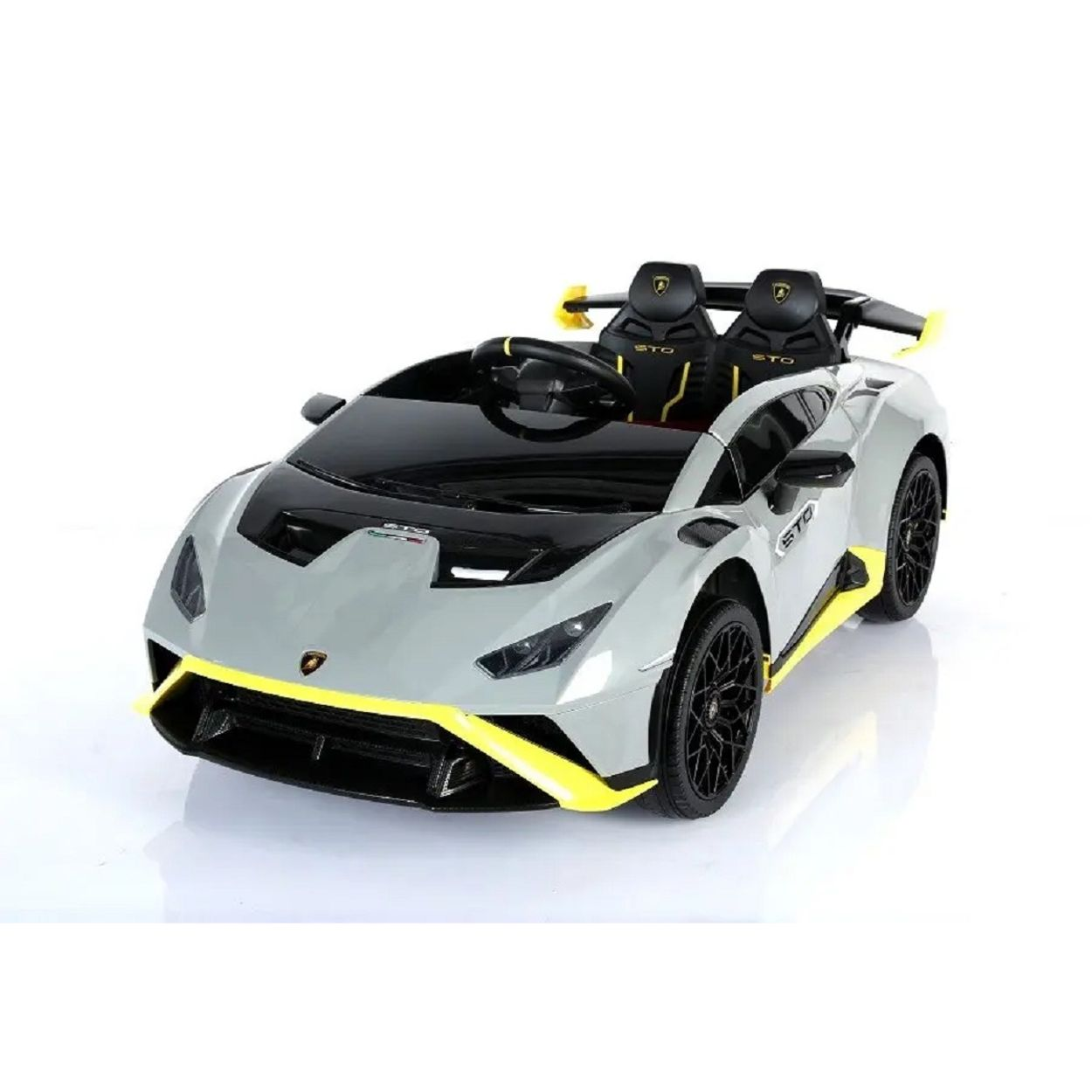 Ein graues Lamborghini-Kinderauto mit gelben Akzenten und schwarzen Sitzen steht auf weißem Grund.
