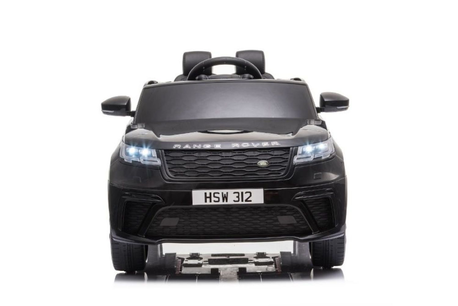 Ein schwarzes elektrisches Kinderauto von vorne mit eingeschalteten Scheinwerfern.