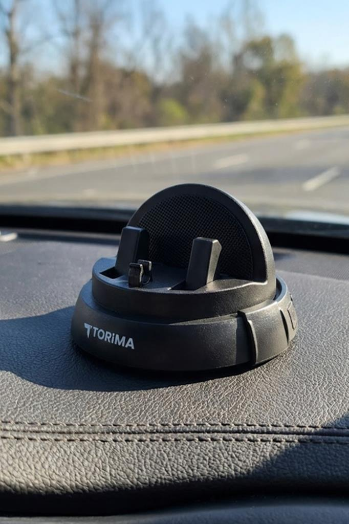 Arabanın ön konsolunda siyah bir Torima akıllı telefon tutacağı, arka planda otoyol görünüyor.