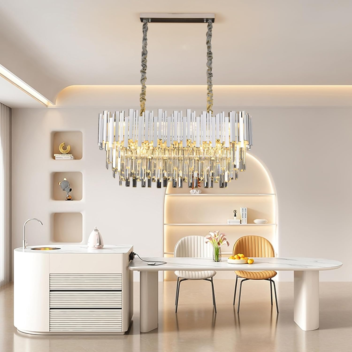 Moderne Kristall-Hängeleuchte über einem weißen Esstisch mit Stühlen in einem hellen, eleganten Raum.