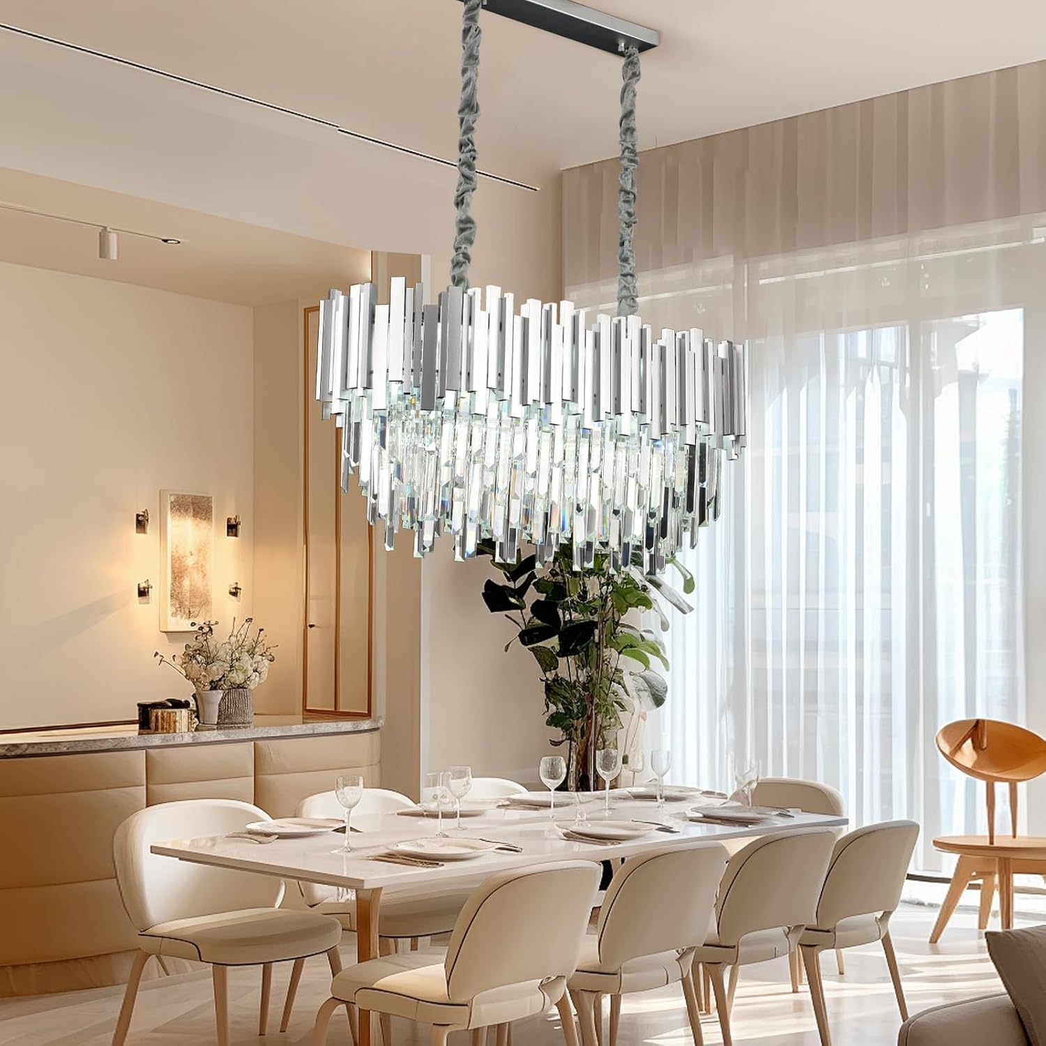 Eleganter Kristall-Kronleuchter über einem modernen Esszimmertisch mit weißen Stühlen in einem hellen Raum.