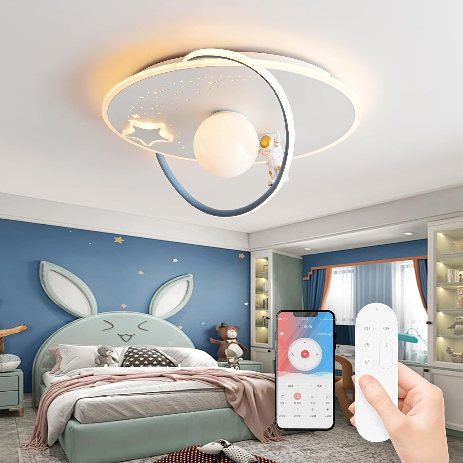 Ein Kinderzimmer mit raumbezogener Deckenlampe, Hasenbett und Hand mit Fernbedienung und Smartphone.