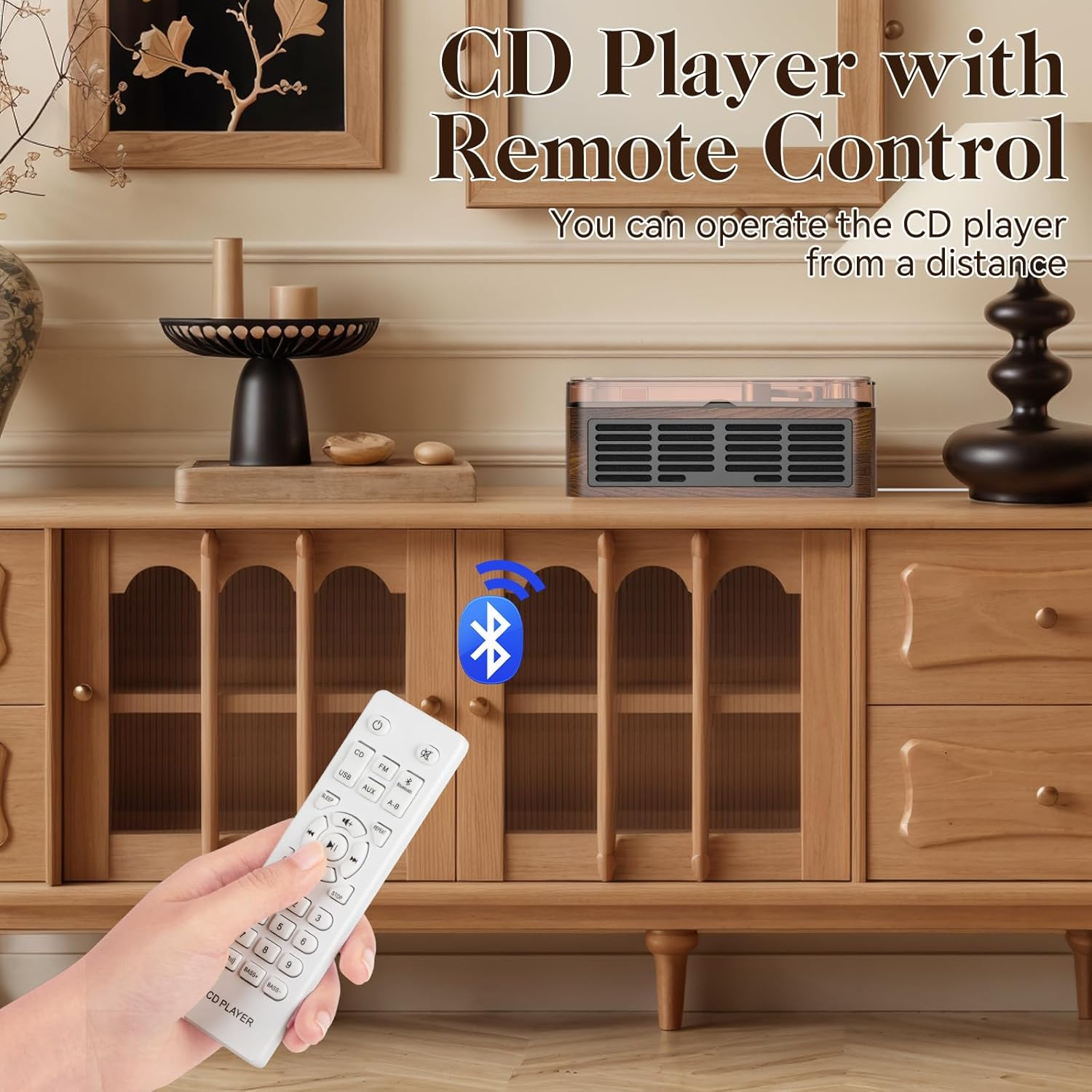 Eine Hand hält eine weiße Fernbedienung vor einem CD-Player auf einem Schrank mit Bluetooth-Symbol.
