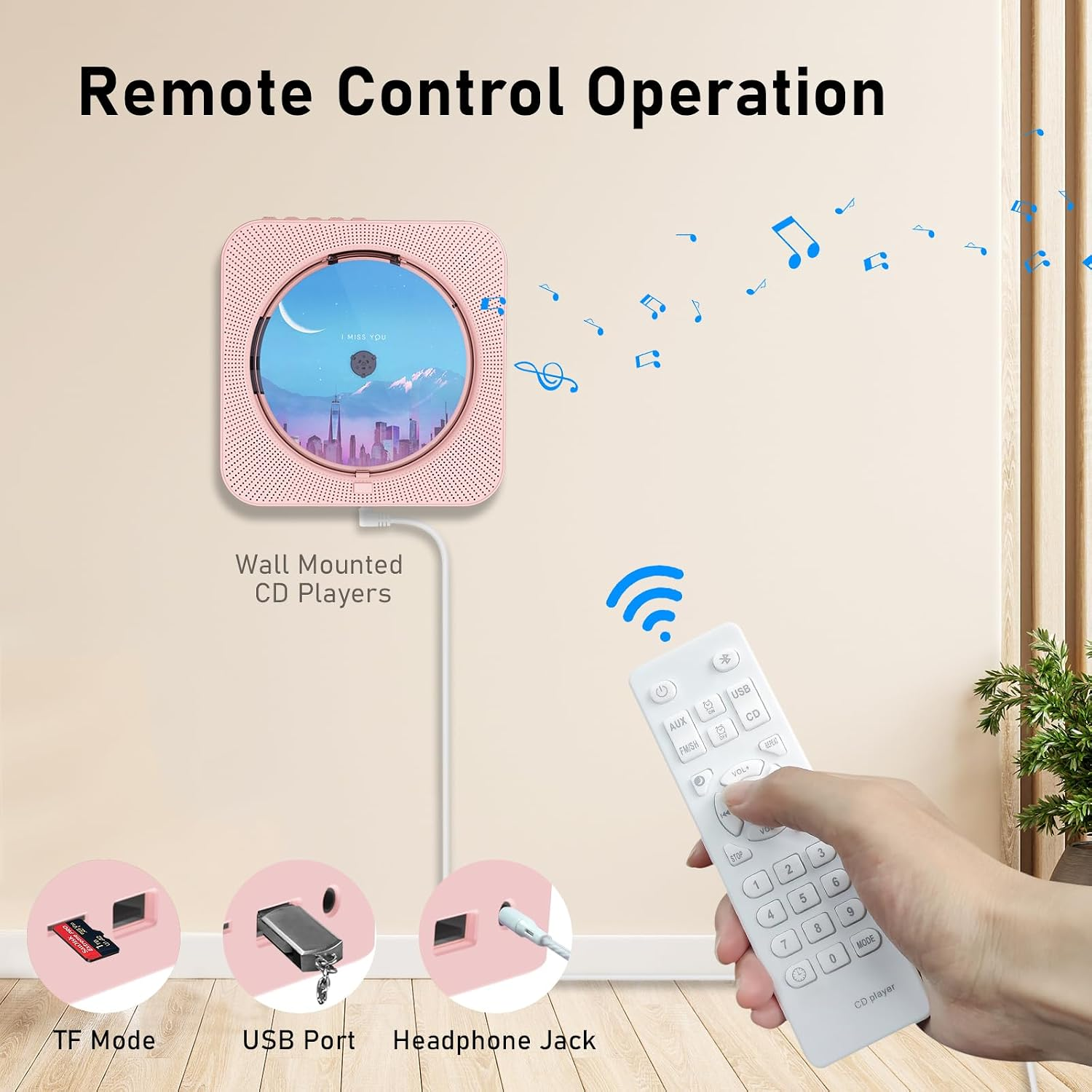 Eine Hand bedient einen rosafarbenen CD-Player an der Wand mit einer Fernbedienung, darunter TF-, USB- und Klinkenanschlüsse.