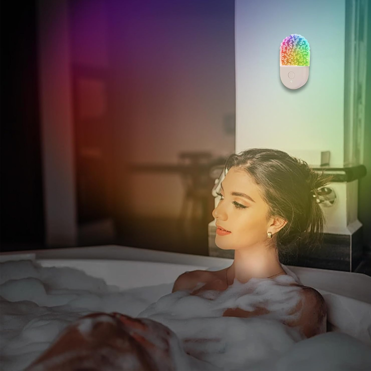 Eine Frau entspannt in einer Badewanne voll Schaum, beleuchtet von einem farbigen Nachtlicht an der Wand.