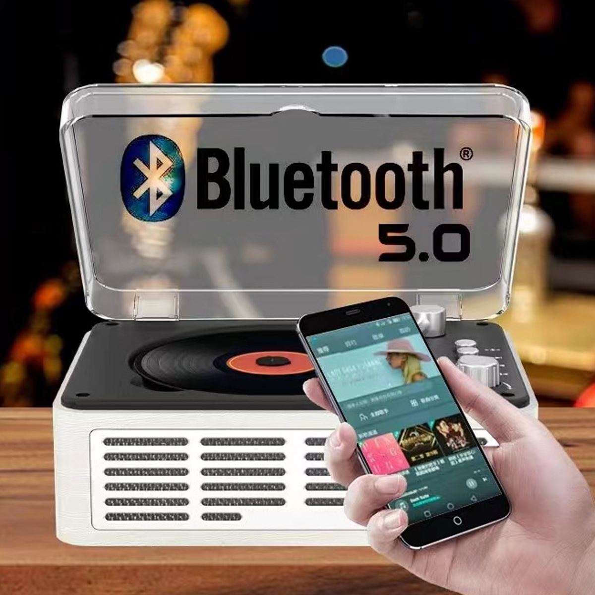 Ein Smartphone zeigt eine Musik-App, im Hintergrund steht ein Retro-Plattenspieler mit Bluetooth 5.0.