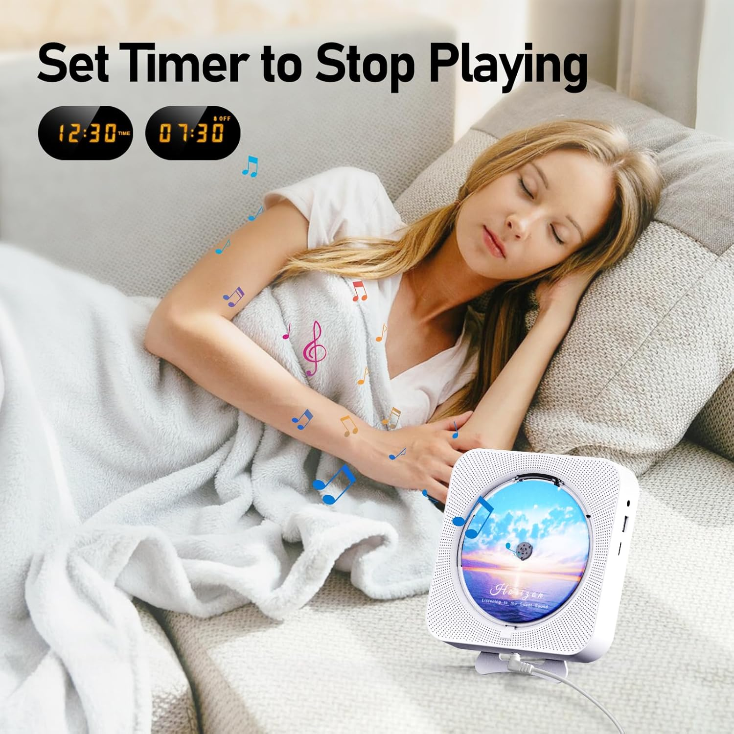 Eine Frau schläft auf einem Sofa unter einer Decke neben einem weißen CD-Player.