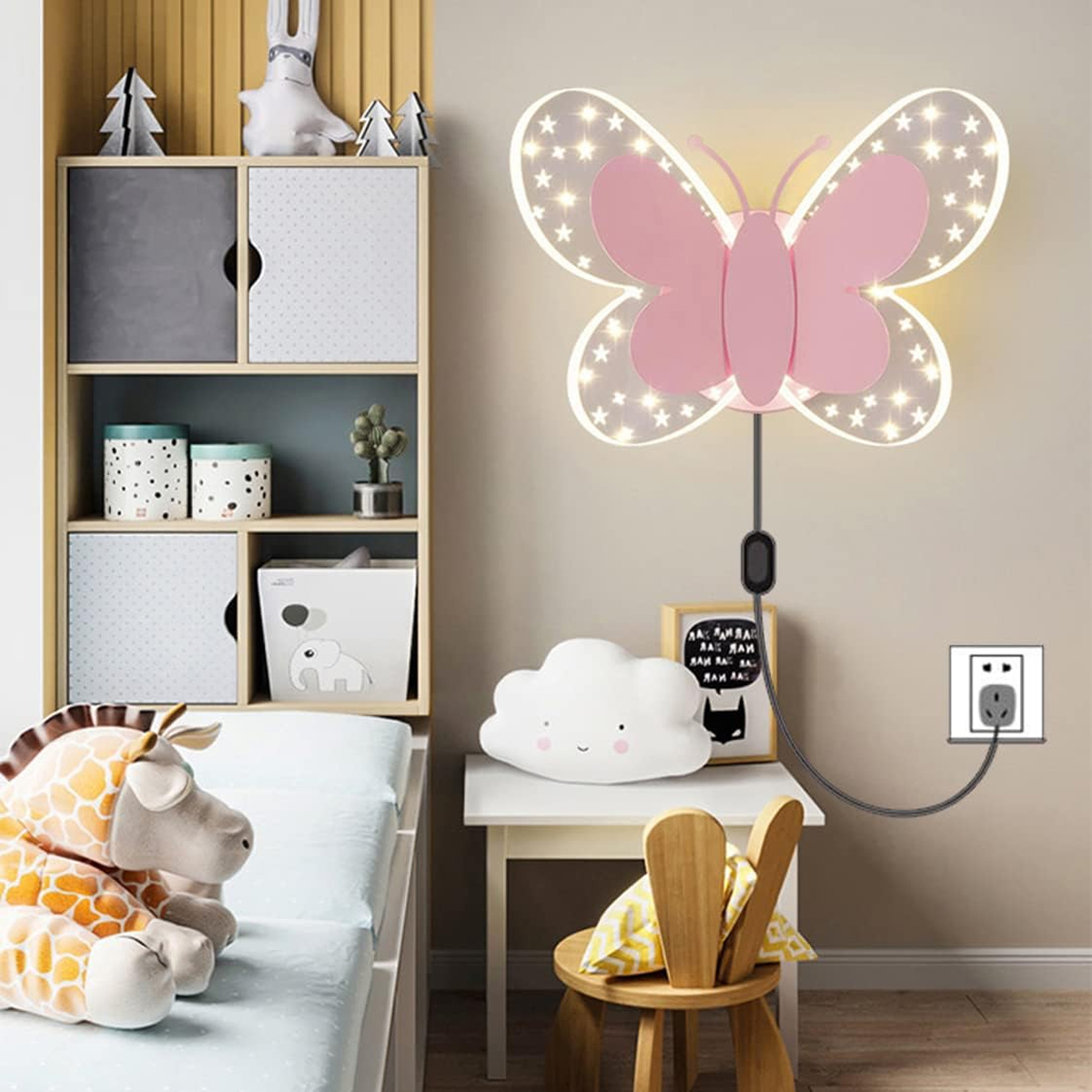 Rosa Schmetterlingswandleuchte mit Lichtern über einem Kinderbett und Spielzeugregal.