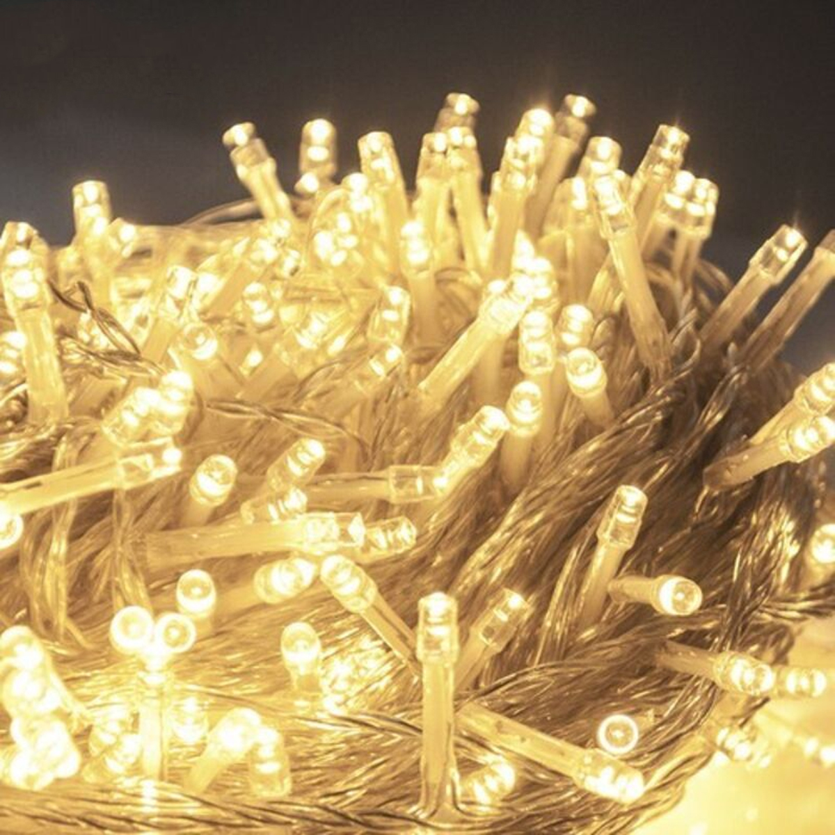 Ein dichtes Bündel hell leuchtender, warmer LED-Lichterketten auf dunklem Hintergrund.