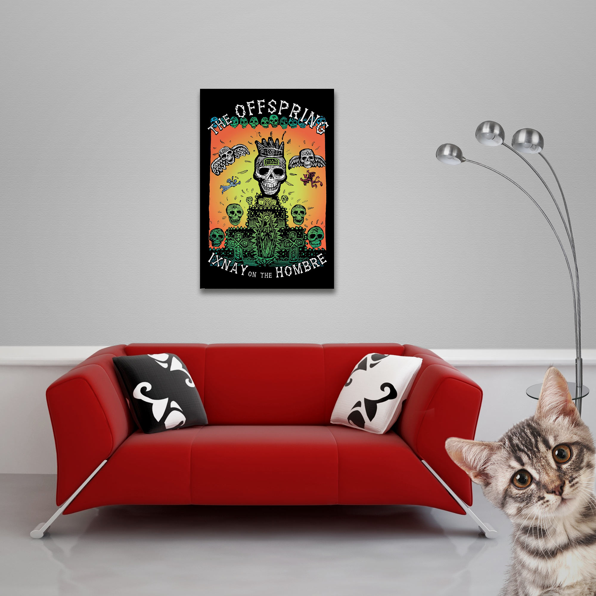 Ein rotes Sofa mit Kissen steht unter einem Offspring-Poster. Rechts schaut eine Katze hervor, daneben eine Stehlampe.