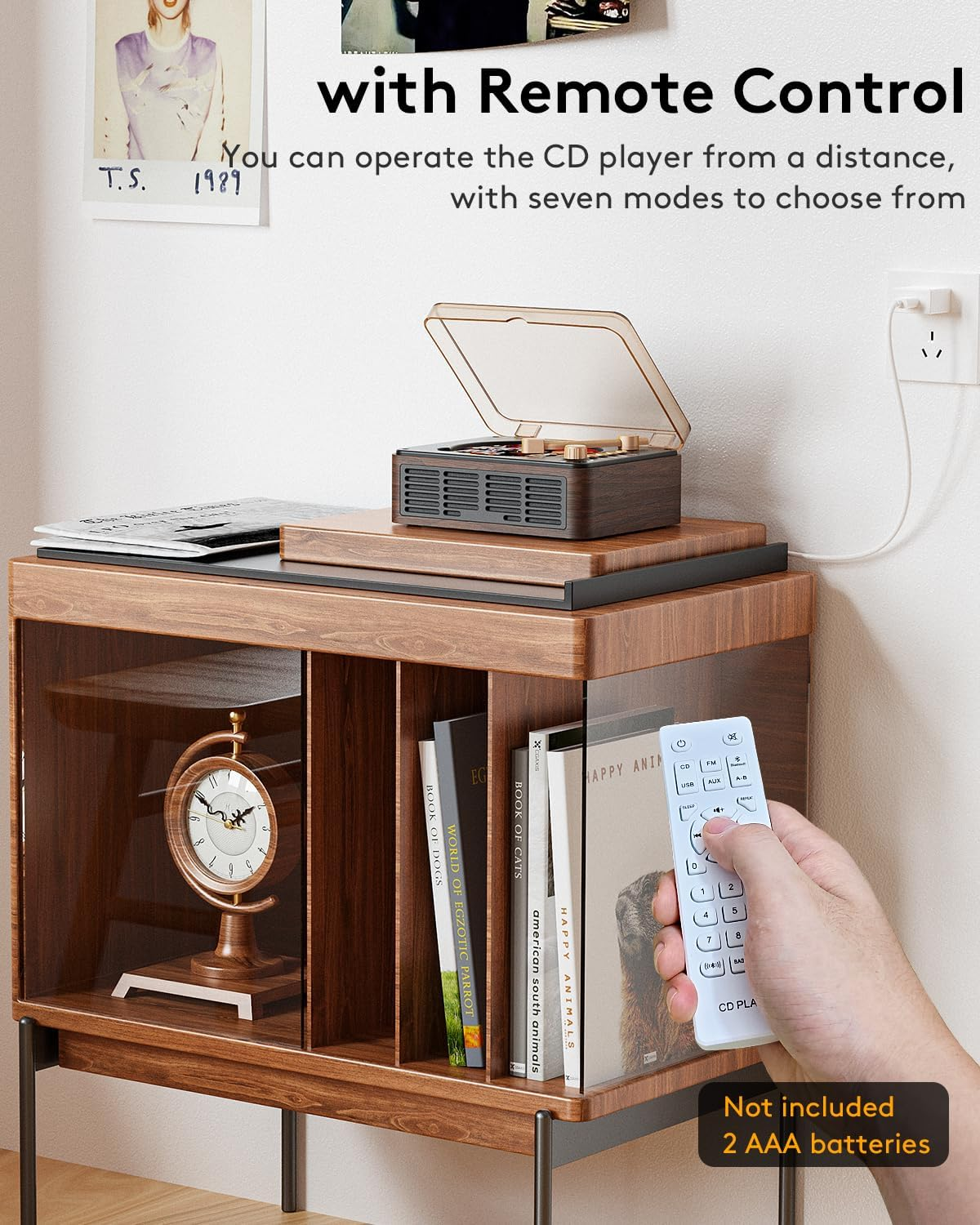 Ein Holzschrank mit CD-Player oben und einer Hand, die eine weiße Fernbedienung hält.