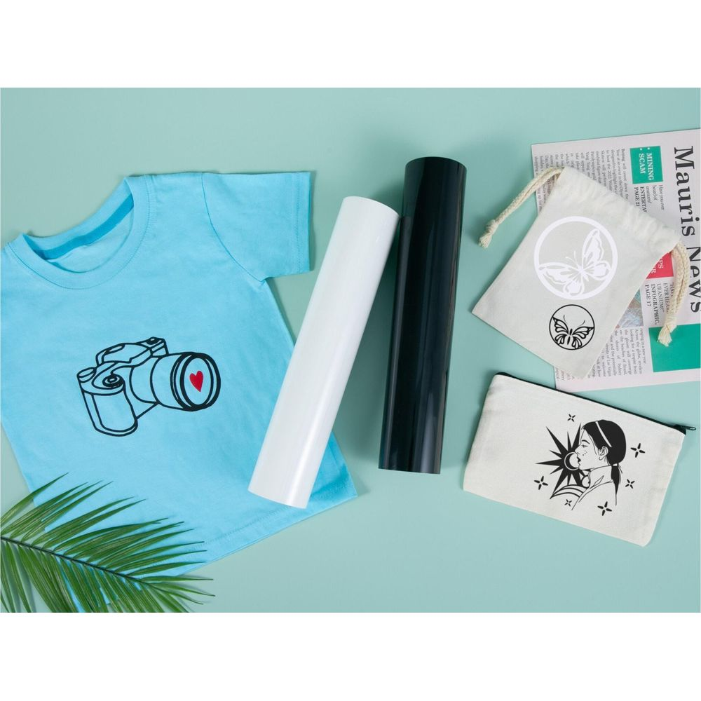 Ein hellblaues Shirt, zwei Vinylrollen, zwei bedruckte Taschen und ein Palmblatt auf türkiser Oberfläche.
